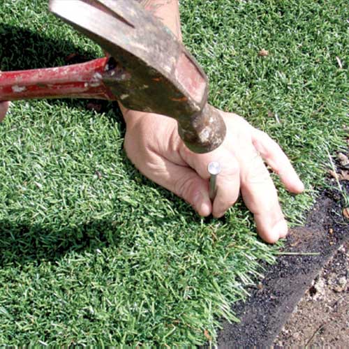 how to secure artificial grass to soil